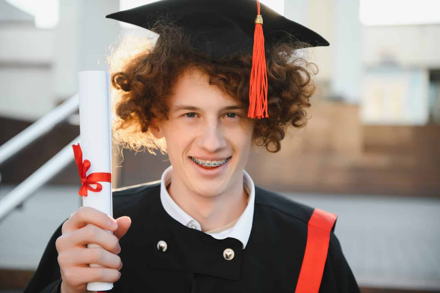 young university graduate in cap and gown